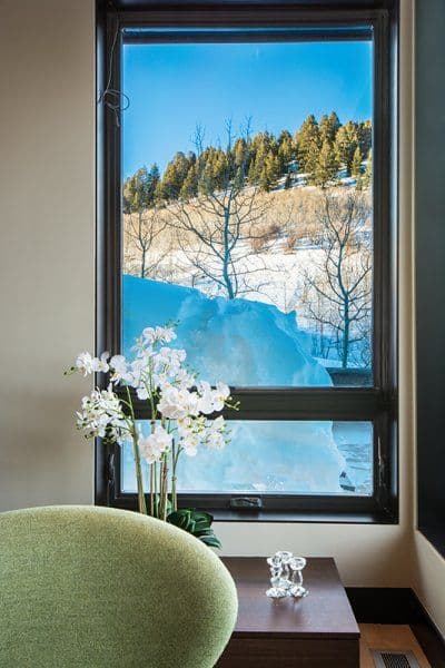 A window looking out on a beautiful view of snow on a hill